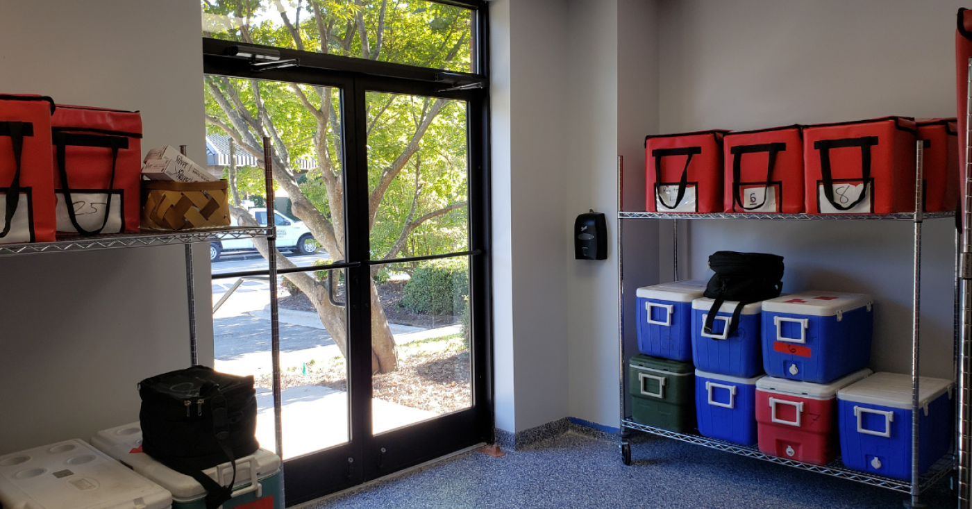 About: Volunteer meal pickup room where full coolers are placed 