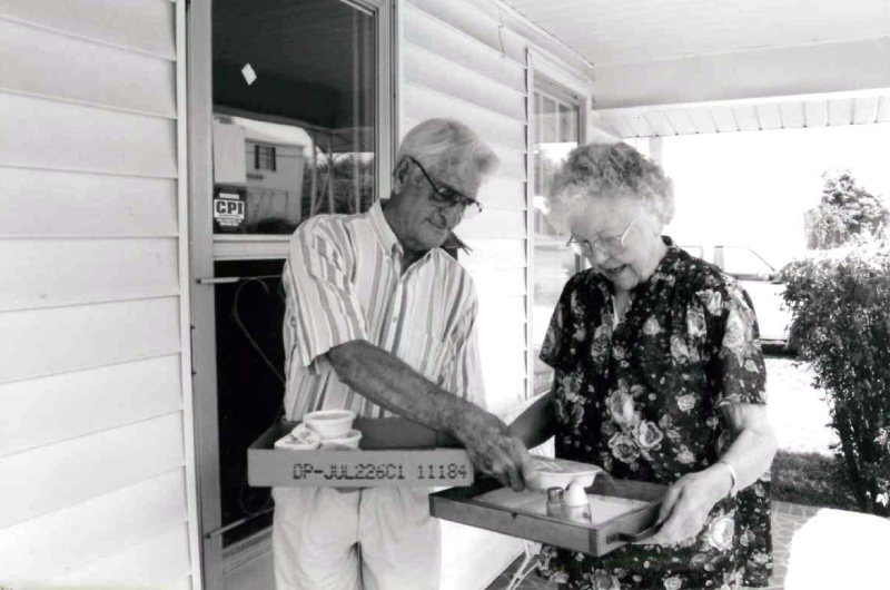 50th Anniversary look back: Newspaper clipping of volunteers outside of a clieint's home delivering meals 
