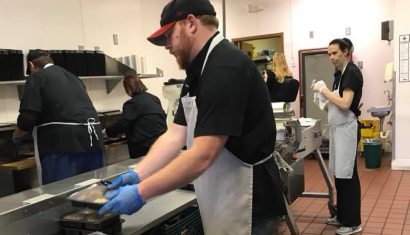 Kitchen Manager Andy Allen stacking meal trays 