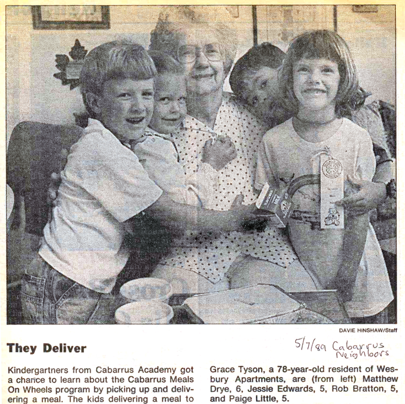 50th Anniversary look back: Newspaper clipping of kindergarten children delivering a meal and hugging a senior woman